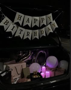 the trunk of a car is filled with birthday decorations