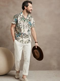 At once rugged and soft, this resort shirt is ideal for travel thanks to a luxurious, breathable cotton fabric and a camp collar for at-ease style.  Camp collar.  Button front.  Straight hem.  Unlined.  Standard fit.  Short sleeves.  Hip length.  Bod Tropical Chic Men Outfit, Formal Hawaiian Outfit For Men, Tommy Bahama Menswear, Tropical Outfit Men Casual, Resort Dinner Outfit Men, Tropical Attire Men, Mens Havana Nights Outfit, Island Cocktail Attire Men, Men Tropical Vacation Outfits