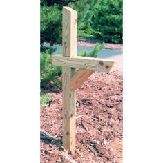 a wooden cross sitting on top of a dirt field