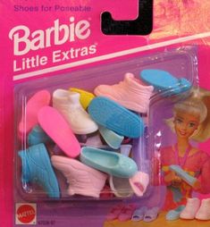 the barbie doll is holding several pairs of shoes in her hand and she's wearing pink