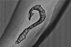 a black and white photo of a tattoo design on the arm with an arrow in it