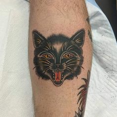 a close up of a person's leg with a tattoo on it and an image of a cat