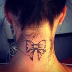 a woman's neck with a bow tattoo on her left side ribcage