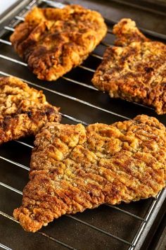 some meat patties are cooking on a grill