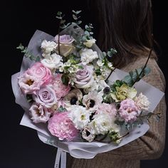 a woman holding a bouquet of flowers in her hands