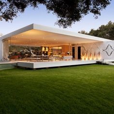 a modern house with grass and trees in the background