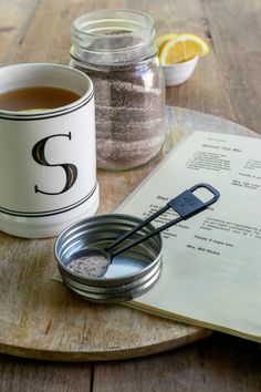 there is a cup of tea next to a book and a spoon on the table