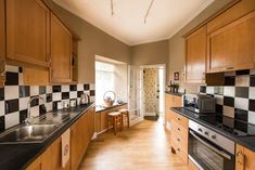 a kitchen with wooden cabinets and black counter tops