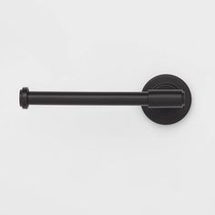 an image of a black towel bar on a white wall with the handle pointing up