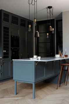 a kitchen with blue cabinets and white counter tops