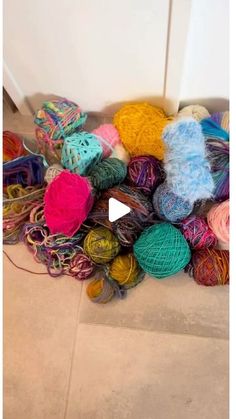 a pile of balls of yarn sitting on top of a floor next to a door