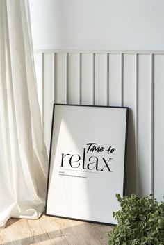 there is a sign that says time to relax on the floor next to a potted plant