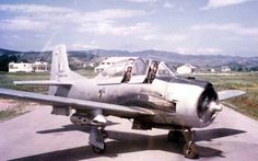 an old fighter jet sitting on top of a cement runway