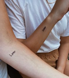 two people with tattoos on their arms and one has the word love tattooed on it