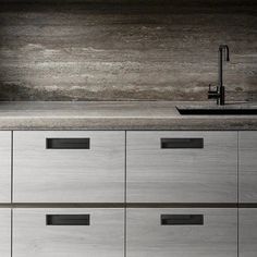 a kitchen counter with drawers and a faucet in the middle, next to a sink