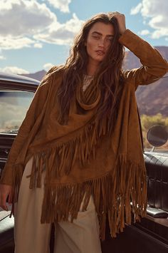 Bold and beautiful, the Trisha wrap jacket boasts 7" of fringe along its hem for movement and western-inspired style. Crafted from soft, supple goatskin suede leather, it can be worn two ways, both equally stunning: open, with the sides cascading down; or wrapped, with one side secured at the shoulder with a corozo button closure. Either way, you'll be the picture of rustic elegance. Featuring lined sleeves for comfortable wear. Wrap is 31 3/4" long plus 7" of fringe along hem. Bohemian Long Sleeve Leather Jacket For Fall, Bohemian Long-sleeve Leather Jacket For Fall, Rodeo Outerwear With Tassels, Fall Leather Jacket With Tassels And Long Sleeves, Leather Tassel Outerwear For Fall, Fall Leather Tassel Outerwear, Western Tassel Outerwear For Fall, Fall Festival Leather Jacket, Fringe Outerwear For Fall Festival