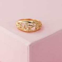 a gold ring sitting on top of a pink box