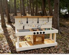 an outdoor kitchen made out of wood in the woods