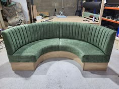 a green curved couch sitting on top of a floor