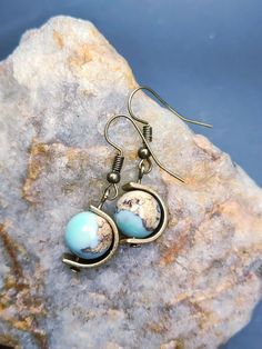 Perfect gift for geography enthusiasts and fidgeters alike! These earrings are made from naturally occurring agate that mimics the look of a tiny planet Earth. Each unique globe rotates on an antiqued brass axis. A thick, durable brass frame protects and spins around each globe. Globe Earrings, Tiny Planet, Earth Globe, Brass Frame, Planet Earth, Antique Brass, Jewelry Earrings Dangle, Planets, Etsy Earrings