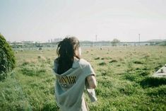 a girl in a white shirt is flying a kite