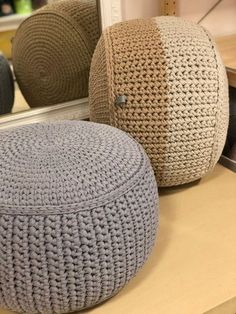 two crocheted poufles sitting on top of a table next to a mirror