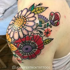 a woman's shoulder with flowers painted on it