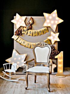 a white rocking chair sitting in front of a wall decorated with stars and garlands