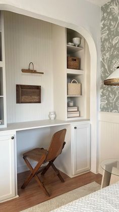 a chair sitting in front of a desk with bookshelves and shelves behind it