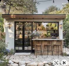 an outdoor kitchen with bar stools and plants