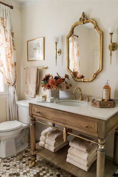 a bathroom with a sink, mirror and toilet in it's centerpieces