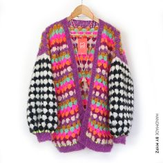 a colorful sweater hanging on a wooden hanger