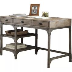 an old desk with drawers and a basket underneath it on a white background in front of a framed photo