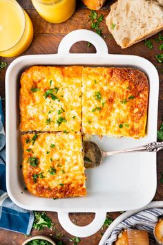 a casserole with cheese and parsley in a white dish on a wooden table