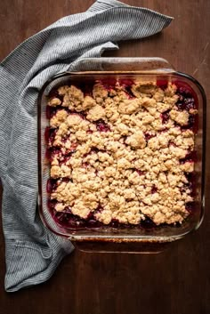 a casserole dish filled with blueberries and crumbs