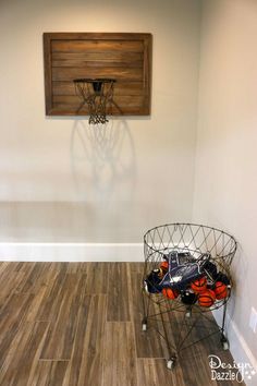 a basketball hoop and basket in the corner of a room with hard wood flooring