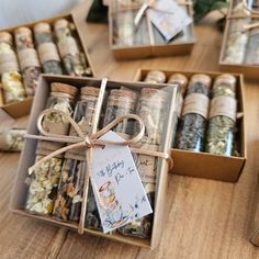 several small boxes filled with different types of spices and herbs on a wooden table next to each other