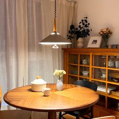 a dining room table with chairs and a vase on it