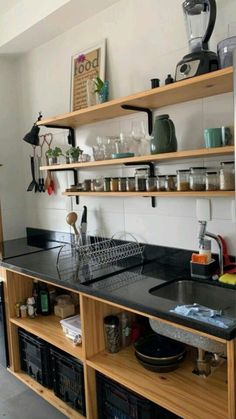 a kitchen with open shelving and black counter tops