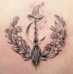 a tattoo design with flowers and a wizard's hat on the top of it