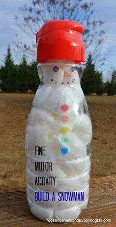 a plastic bottle filled with cotton balls sitting on top of a wooden table next to a tree