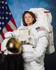 a woman in an astronaut suit holding a golden helmet next to the american flag on a blue background