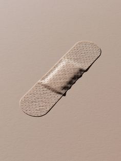 a white skateboard laying on top of a brown floor next to a pink wall