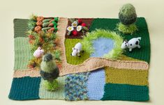 a knitted rug with animals and plants on it