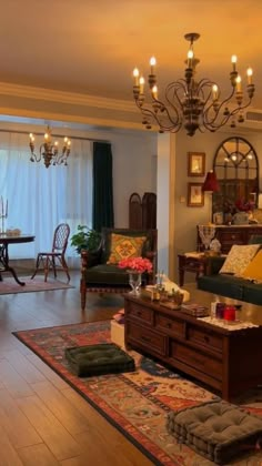 a living room filled with furniture and a chandelier hanging over the top of it