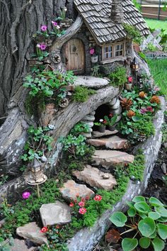 a fairy house built into the side of a tree trunk with flowers growing on it