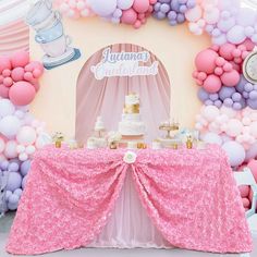 a pink and white dessert table with balloons on the wall in the shape of a teapot