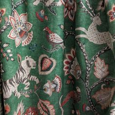 closeup of green fabric with animal and flower designs