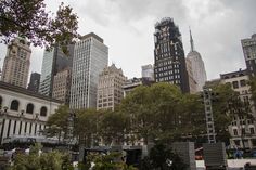 the city is full of tall buildings and people are sitting on benches in the park