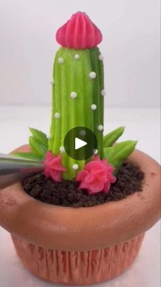 a fake cactus in a clay pot with pink flowers